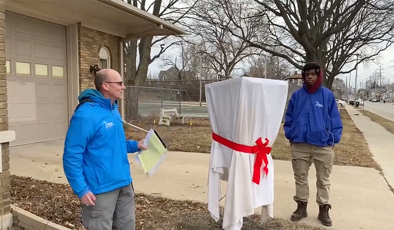 Chris Litzau and Great Lakes CCC team member unveiling solar powered charging station